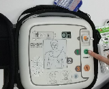AEDのボタンを押す写真