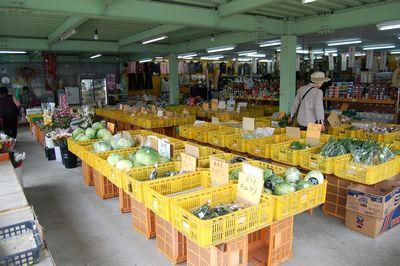 黄色いかごに入った、たくさんの野菜や加工品が並ぶ店内の写真