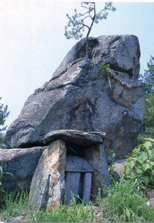 巨大な岩が祀ってあり中央から木が生えている鬼ヶ臼伝承遺跡群の写真