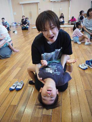 お母さんの膝の上に座っている男の子が体を後ろに反っている写真