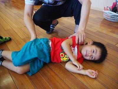 左側を下にして横になっている男の子の写真