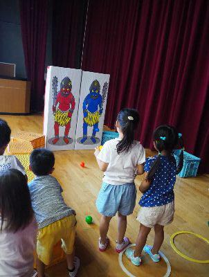 赤鬼と青鬼が描かれたパネルを見ている子供たちの写真