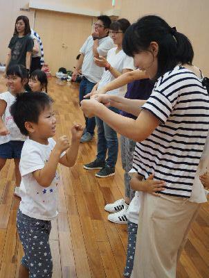 男の子とお母さんが両手でグータッチをしようとしている写真
