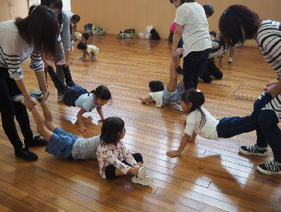 子どもたちが床に手をついていて、お母さんたちが子供たちの両足を持っている写真