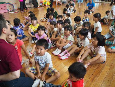 子ども達が集まって、床に体操座りをしている写真