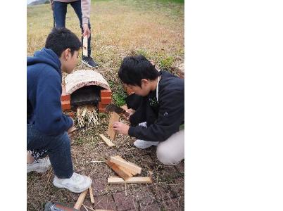 鉈で木の板を細く割る子どもたち