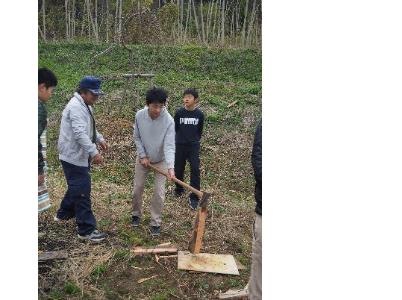 地域の方から薪割りを教わる子どもたち