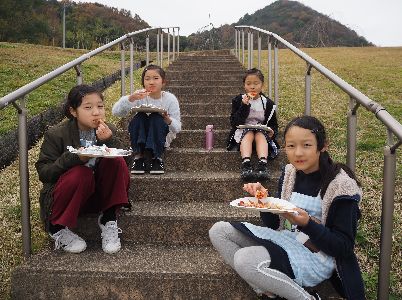 焼きあがったピザをほおばる子どもたち