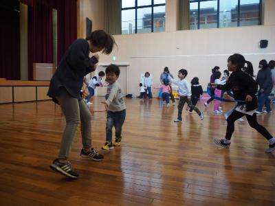 しっぽとりゲームで大人からハチマキをとる子ども