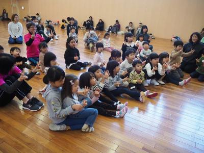 座って手遊び歌を歌う子どもたち