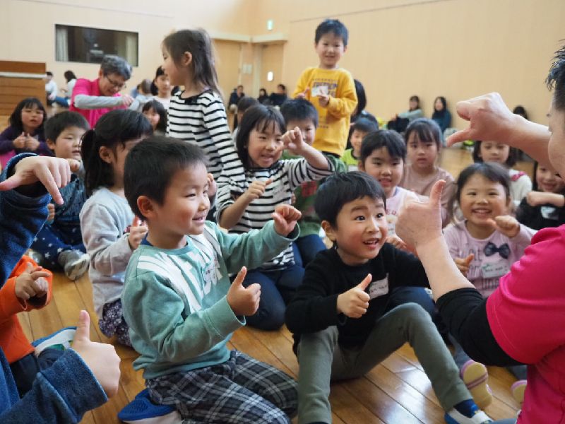 スタッフと一緒に手遊びをする子どもたち