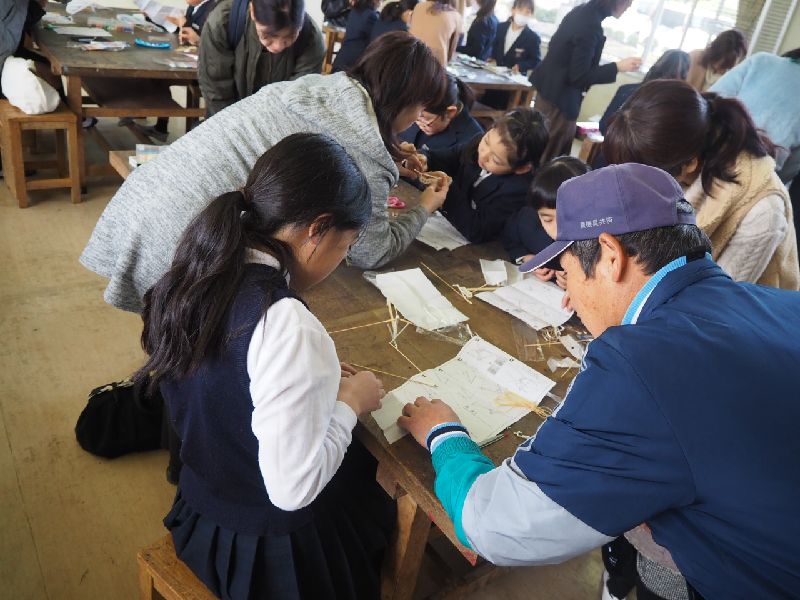 地域の方に工作を教えてもらう子ども