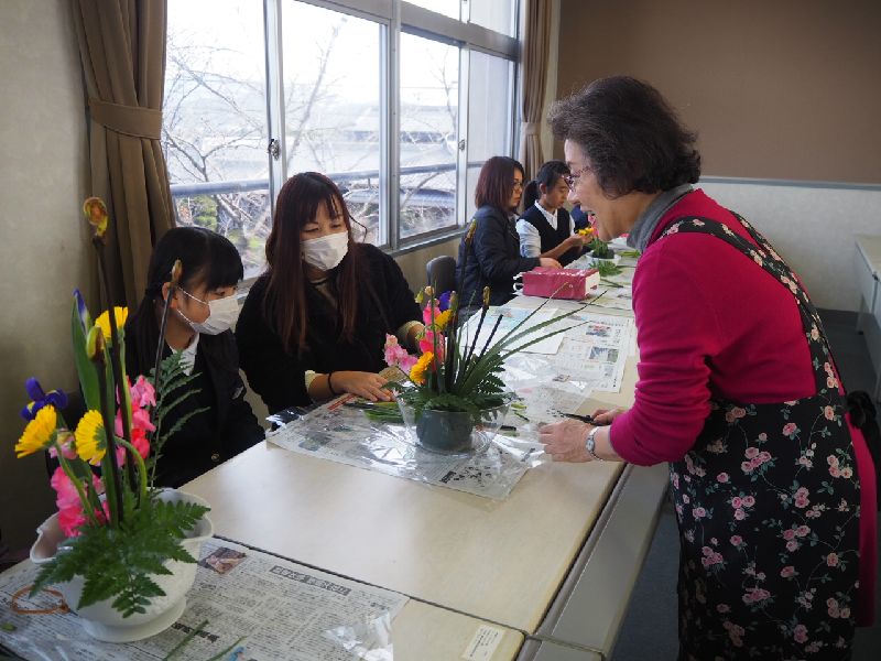 親子が活けた花を地域の方に手直ししてもらっている