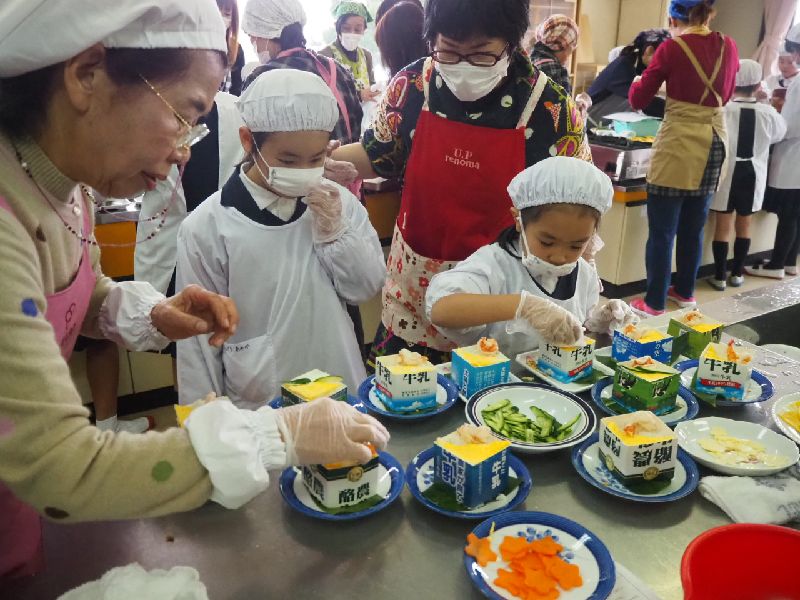 地域の方に料理を教わる子どもたち