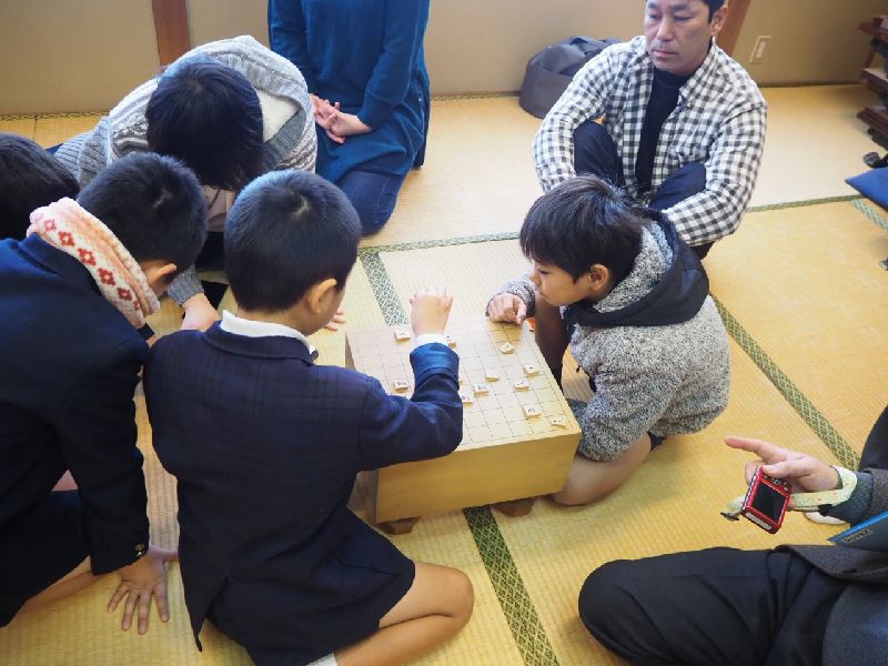 将棋盤で将棋をさす子どもたち