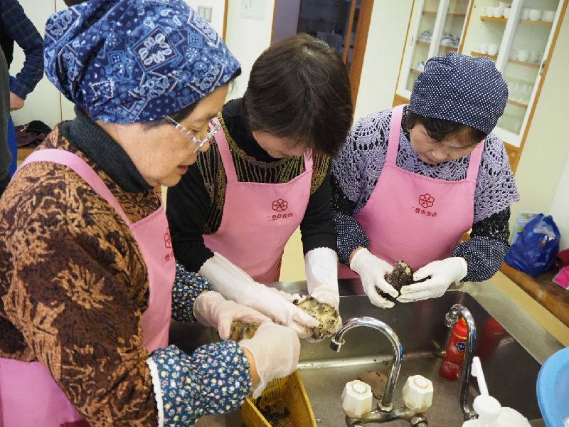 茹でた芋の皮を手でむく参加者たち