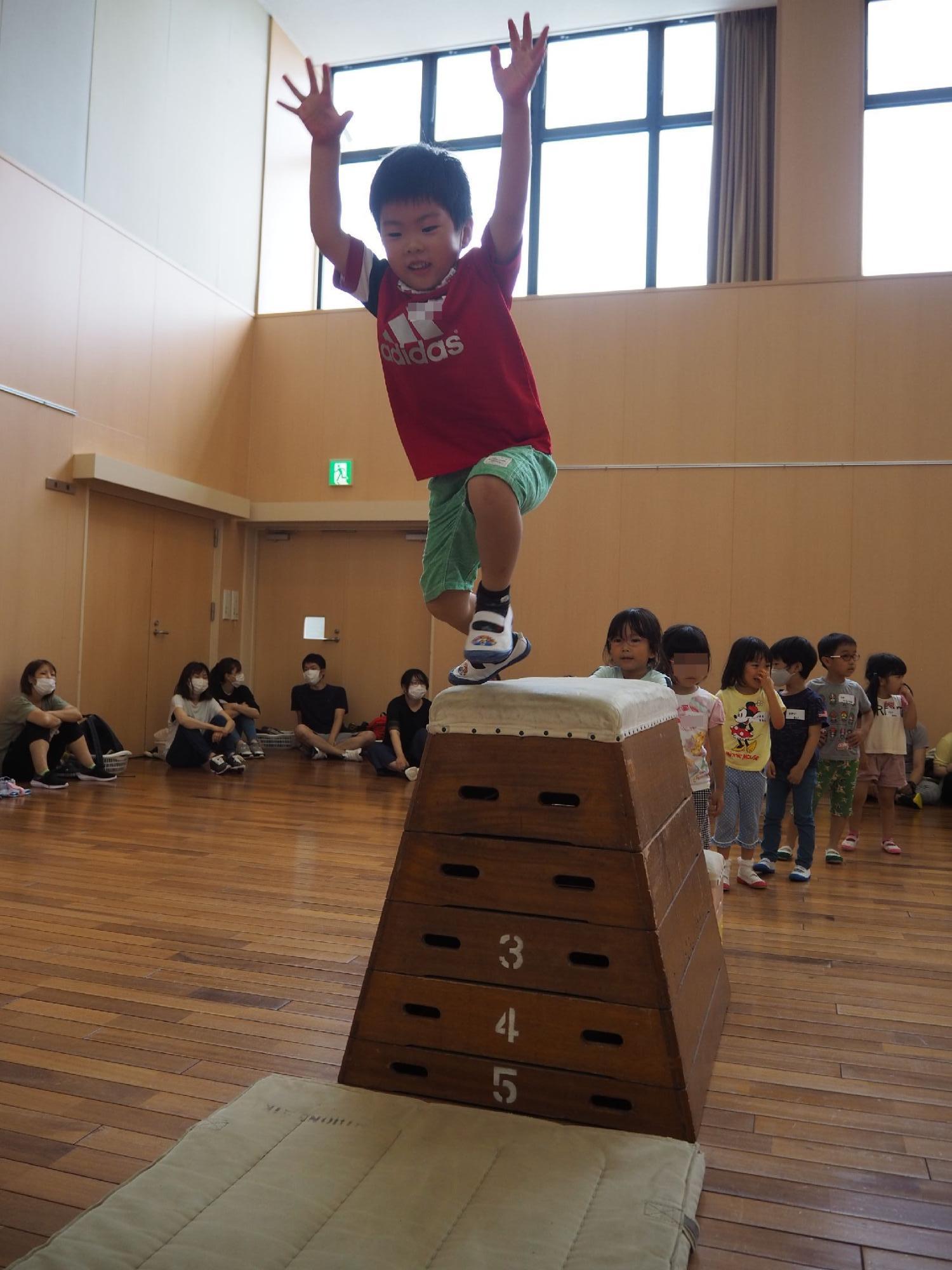 跳び箱からジャンプする子ども