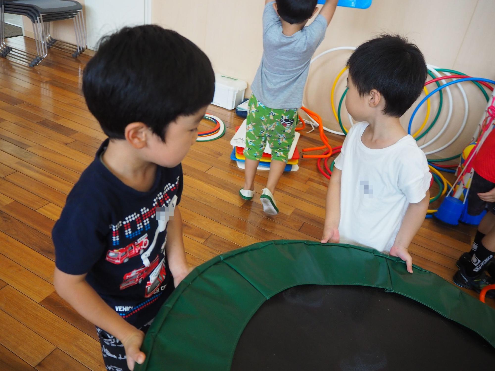 トランポリンを片付ける子どもたち