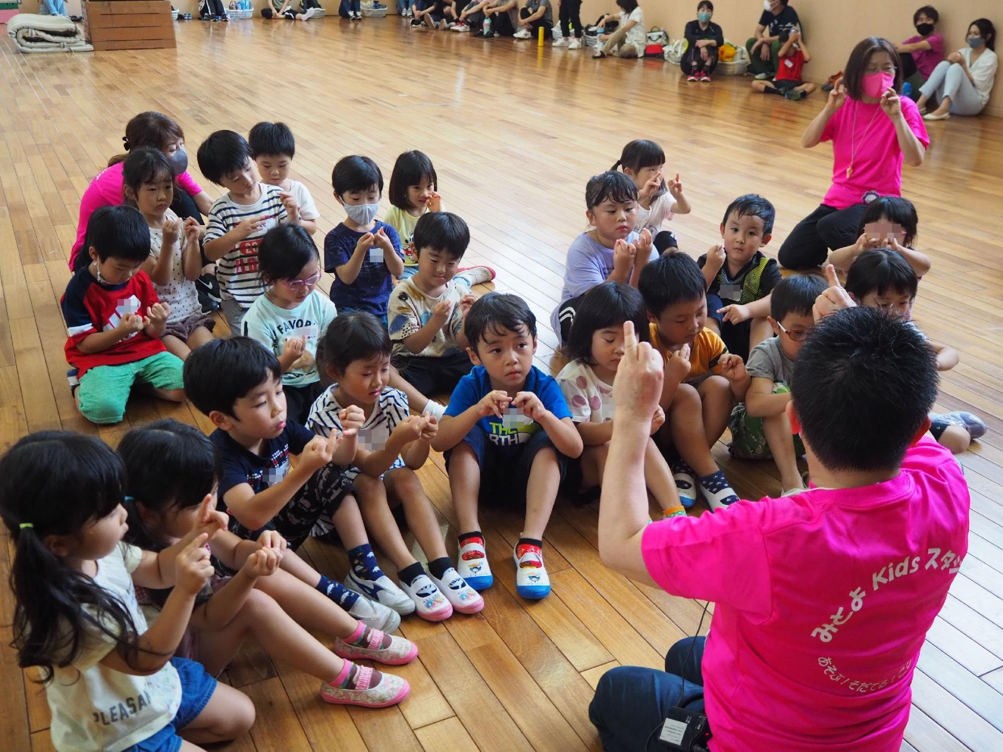 真剣に手遊びを教わる子どもたち