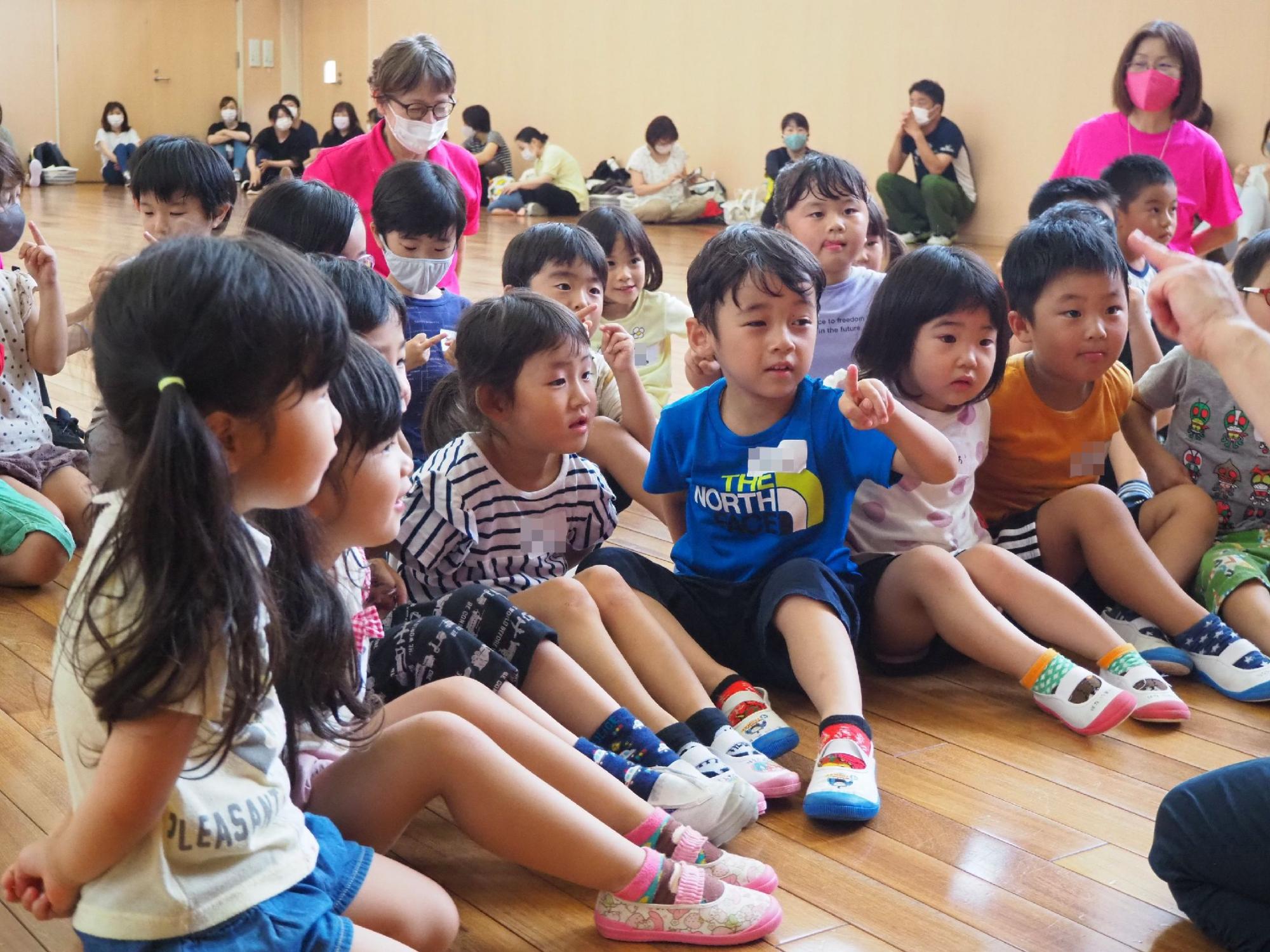 スタッフと手遊びをする子どもたち