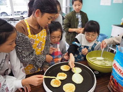 ホットプレートでパンケーキを焼く子どもたち