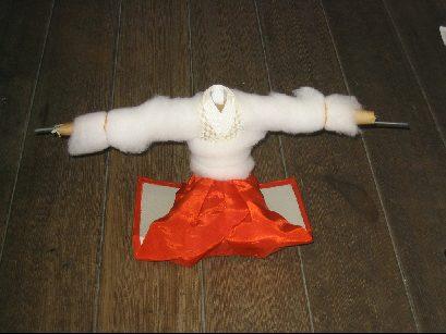 床の上に人形の作成途中の人の体の形をした綿が置いてある写真
