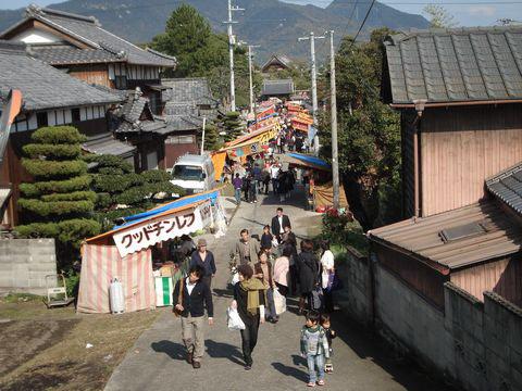 大坊一にて住宅地の中の路上に出店が出店し人で賑わっている写真