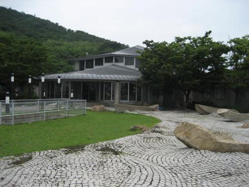 石畳と芝生の奥に建っている「ル・ポール粟島」の外観写真