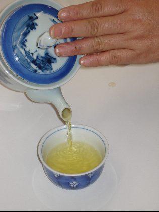急須から湯呑にお茶を注いでいる写真