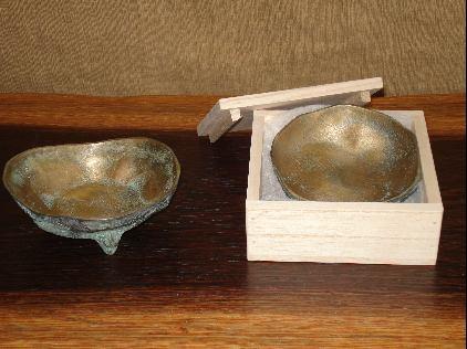 木箱から出してある青銅食器と木箱に入っている青銅食器が並べられている写真