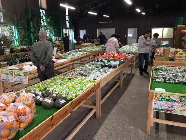 野菜が並んでいる店内でお客様が買い物をしている写真