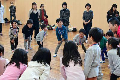 子どもたちが円に並んでチクサクコールをしようと片足を前に出している写真