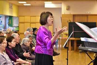 豊岡 真由美先生が歌を歌いながら指揮をしている写真