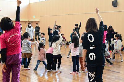 子どもたちが円に並んでみんなで握り拳を作った片手をあげている写真