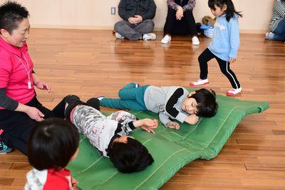 緑の体育マットの上に二人の男の子が寝っ転がっている写真
