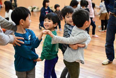 男の子4人がそれぞれ片手ずつ手をつないで繋がっている写真