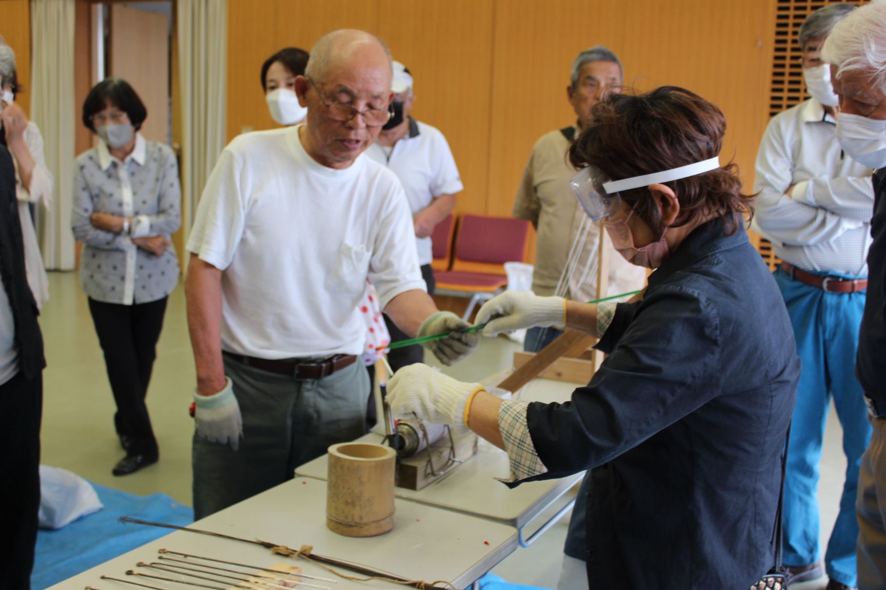 ランプの火で生地がよく溶けた所で丸く巻き付ける作業中