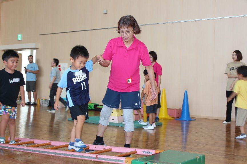 サーキット遊びのはしご渡りをする子ども