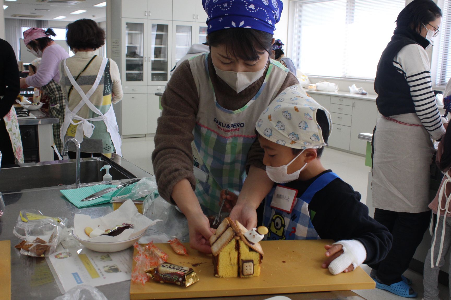 お菓子を飾り付けする親子