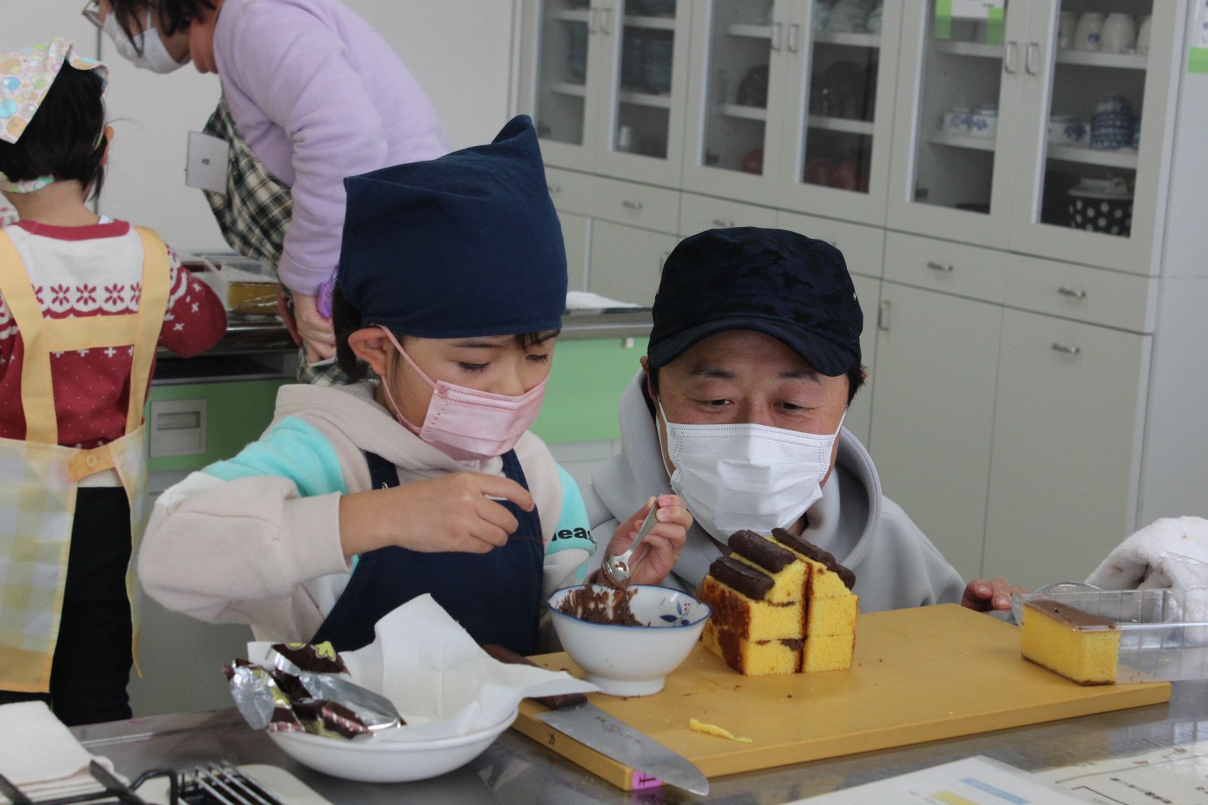 お菓子を飾り付けする親子