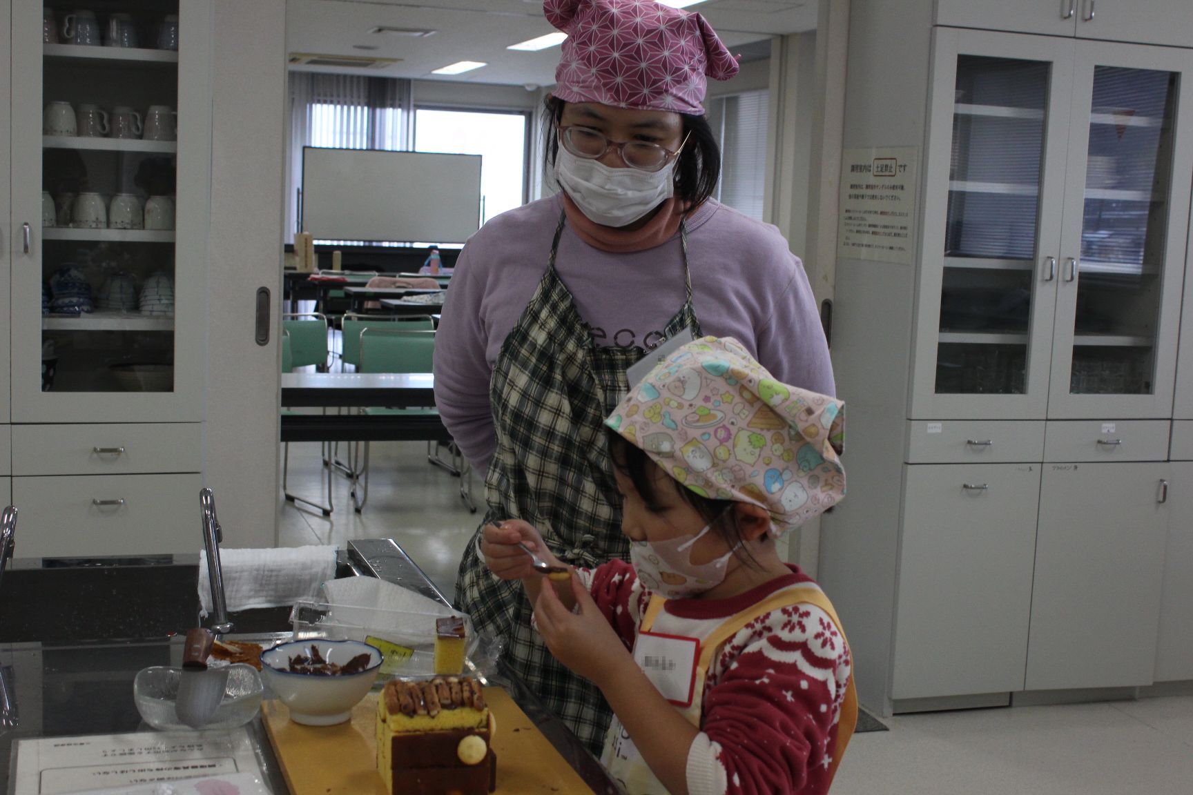 お菓子を飾り付けする親子