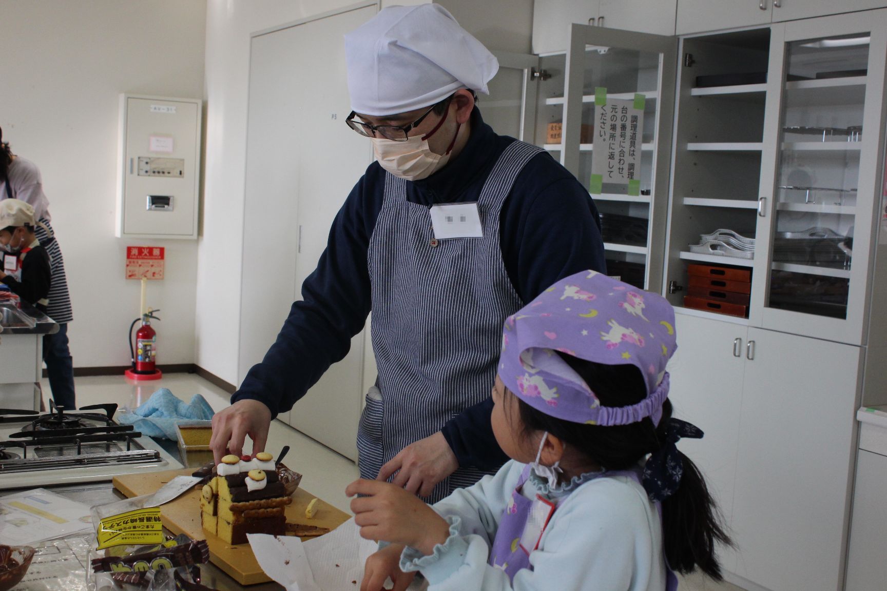 お菓子を飾り付けする親子