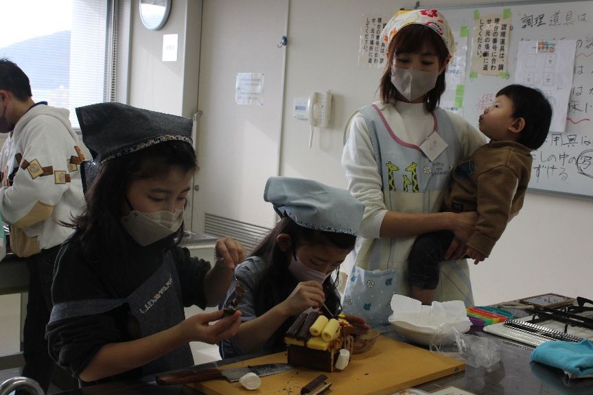 お菓子を飾り付けする親子