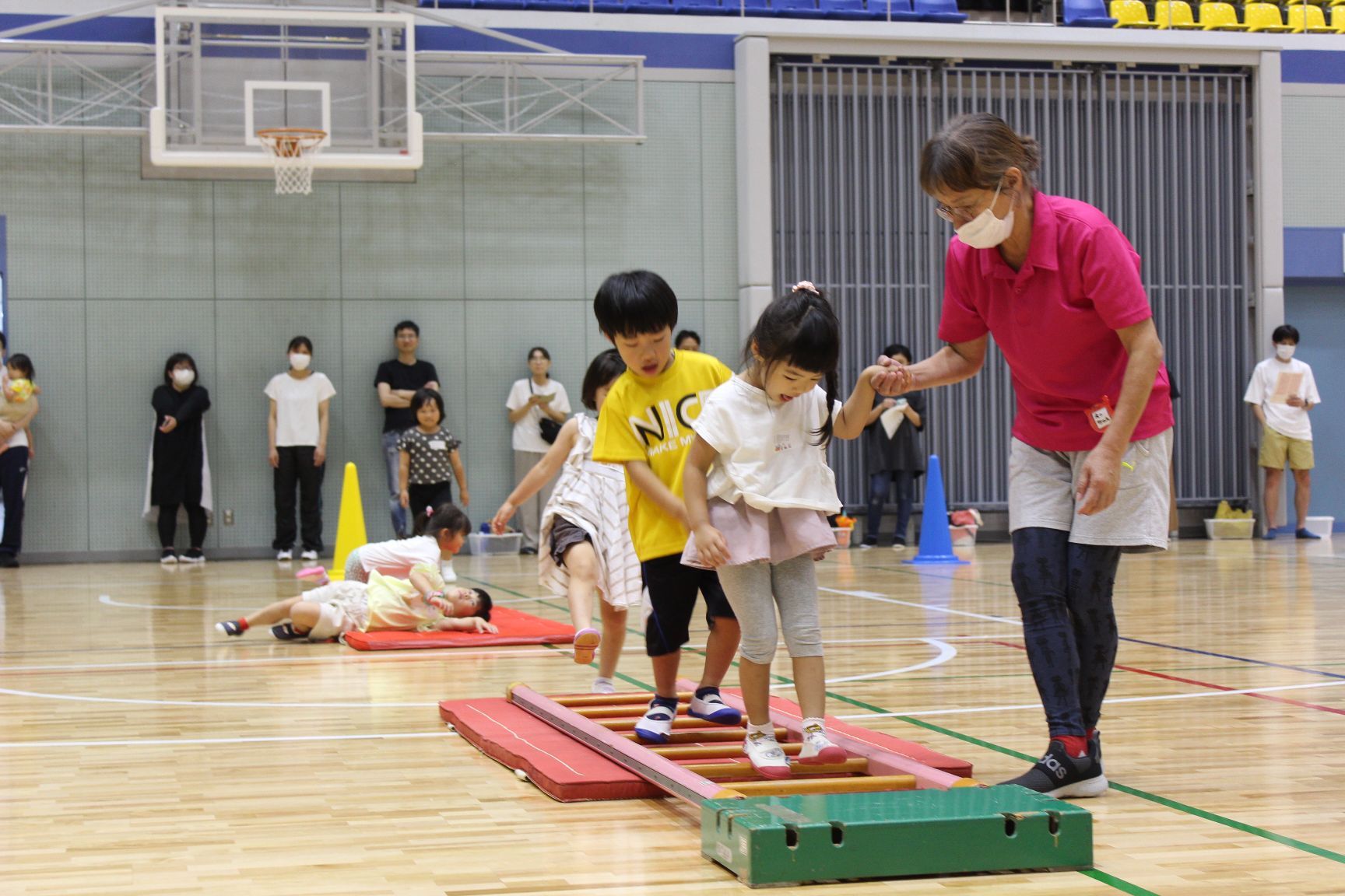 サーキット遊びではしご渡りをする幼児