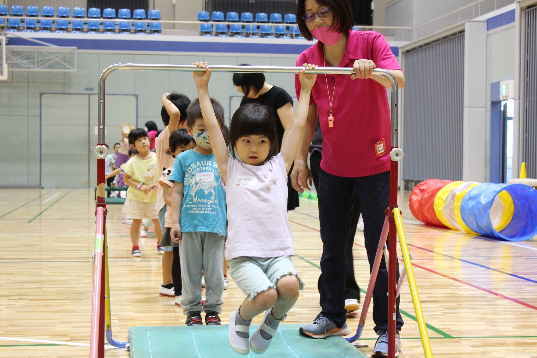 サーキット遊びで鉄棒をする幼児