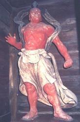 左手を開き右手はまっすぐに伸びている赤い木造金剛力士立像の写真