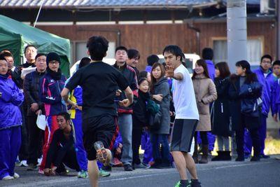 一般男性たちがタスキをつないでいる写真