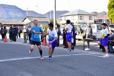 一般男性から中学生男子へタスキをつないでいる写真