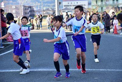 2組のチームの5年生の男子から6年生の女子へタスキをつないでいる写真