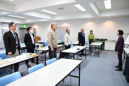 参加者が起立して発声練習をしている写真